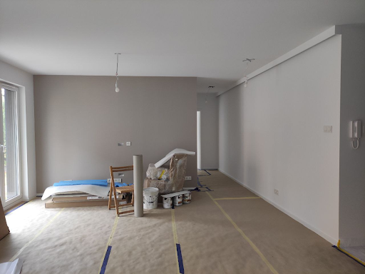 Jak wykończyć mieszkanie deweloperskie - zdjęcie przedstawia mieszkanie w trakcie prac wykończeniowych. Zabezpieczona została podłoga przed zabrudzeniem farbą itp.